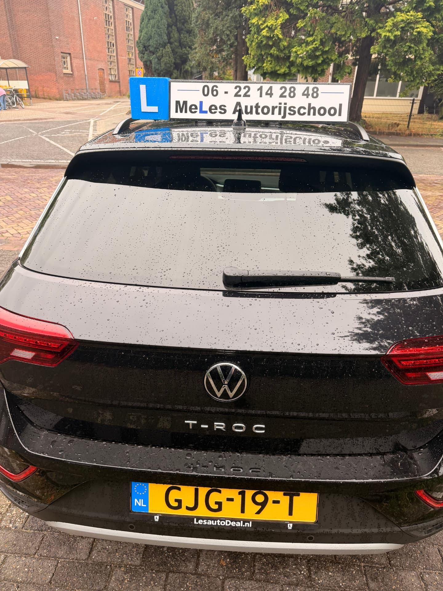 De lesauto van MeLes Autorijschool, een zwarte Volkswagen T-Roc